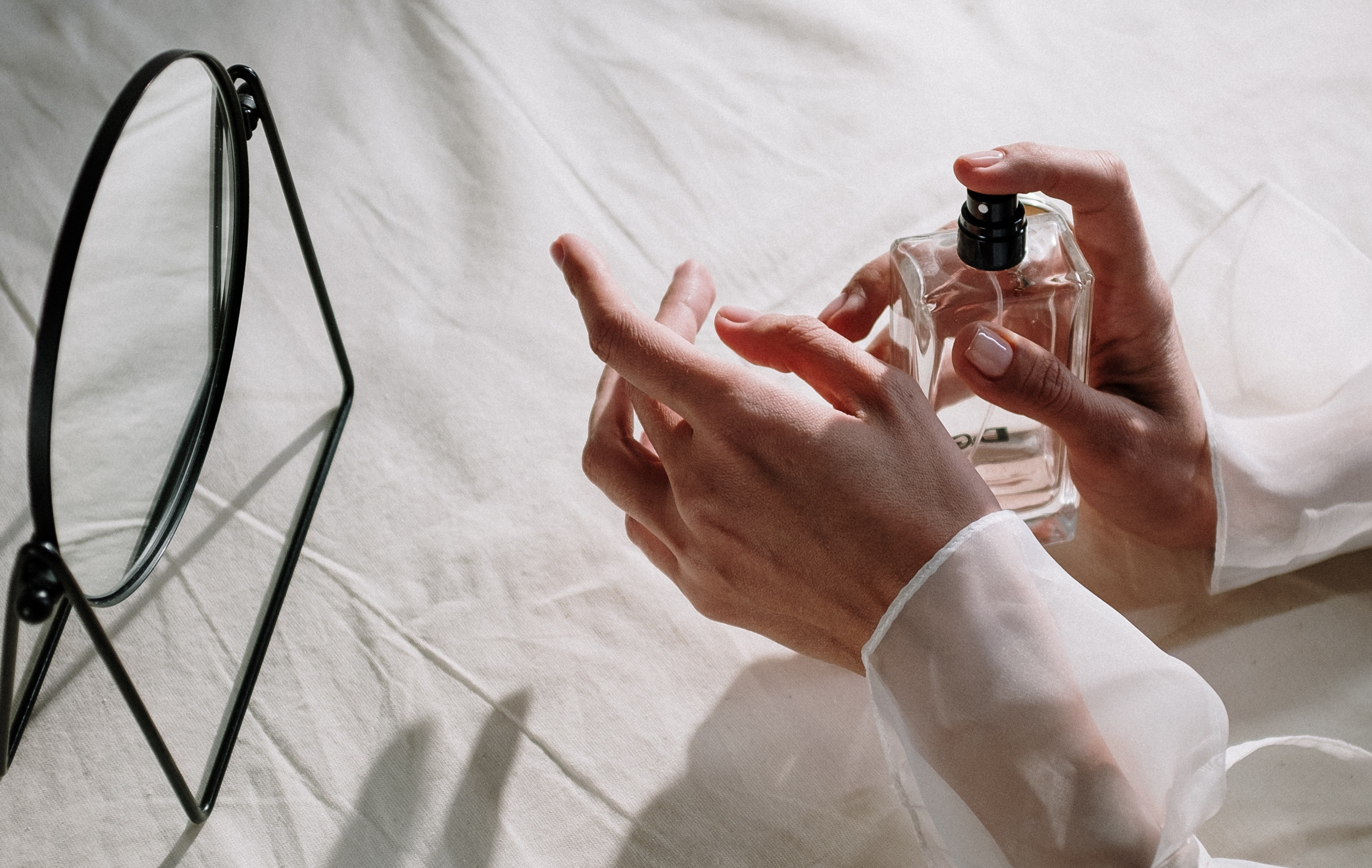 a photograph of a person putting on perfume